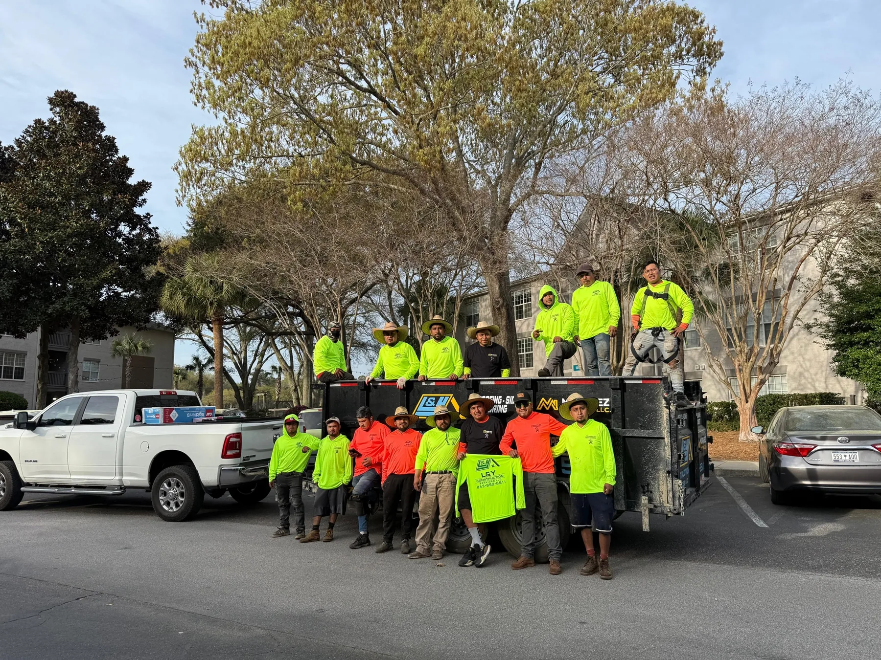 Crew group photo with branded trucks and work trailer