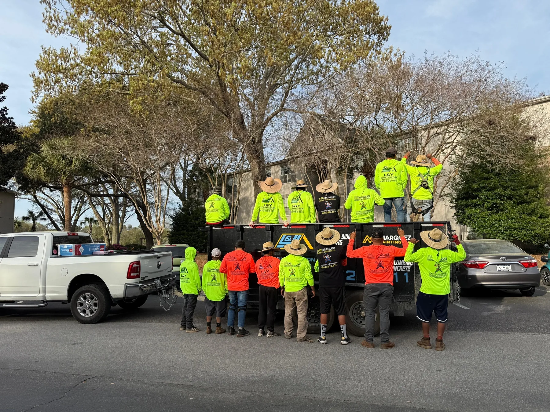 Crew standing near branded vehicles and a work trailer