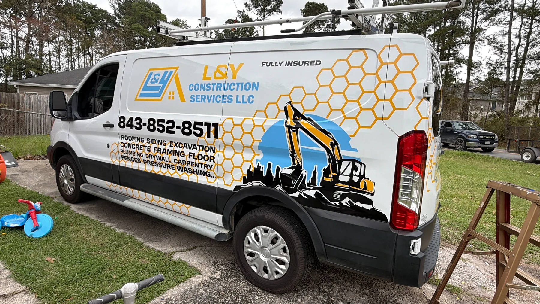L&Y Construction Services branded van beside an active project site