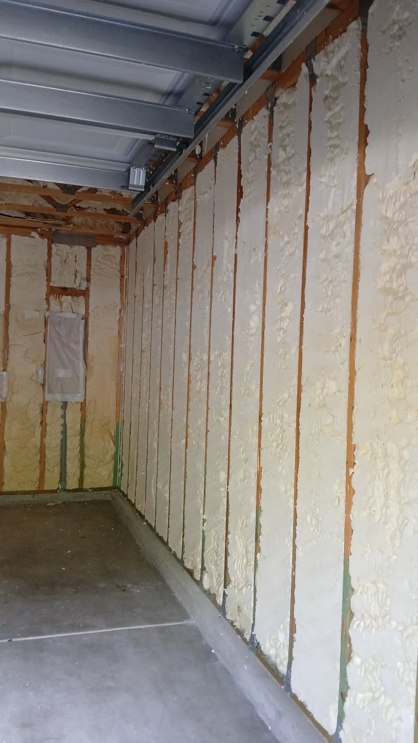 Garage wall bays filled with spray foam insulation during restoration work